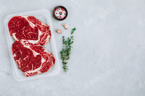 Preview: Ground Beef steak in vacuum packaging with seasonings on gray stone background