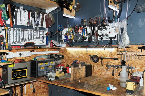 Preview: Empty Workshop Table Surrounded by Tools and Equipment in Garage Setting