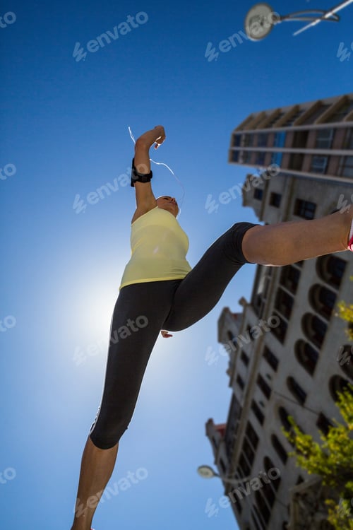 Preview: A beautiful woman jumping in the street on a sunny day