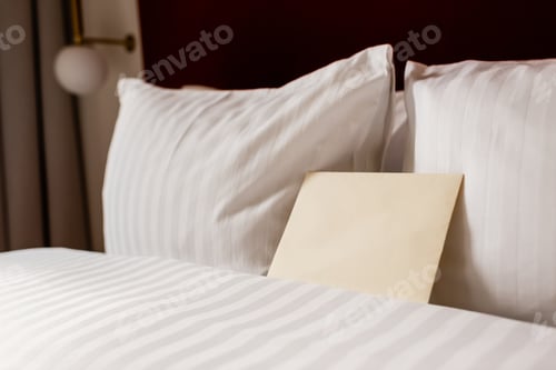 Preview: yellow envelope on white and clean bedding in hotel room