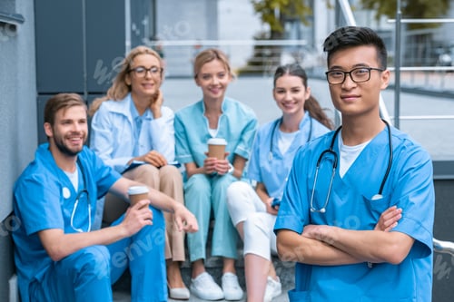 Preview: asian man standing in front of caucasian teacher and students at medical university