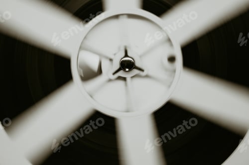 Preview: Monochrome pic of film reels turning. Analog player. Retro old-fashioned 8mm projector playing movie