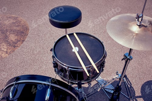Preview: close up view of black drum kit and drum sticks on street