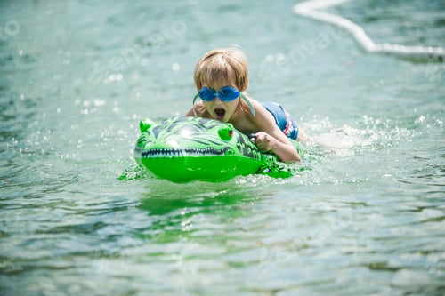 Preview: Young boy with swimmming goggles and swim toy