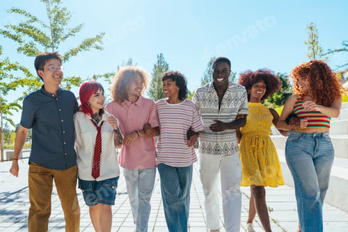Preview: Multiethnic group of young friends meeting and having fun outdoors