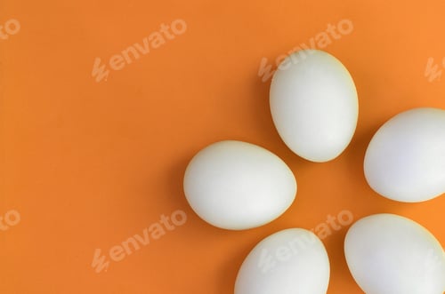 Preview: A few white easter eggs on a bright orange background