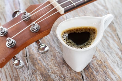 Preview: cup of coffee and ukulele on rustic wood.
