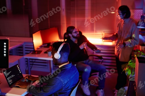 Preview: Young male diversity programmer of African ethnicity working in front of laptop