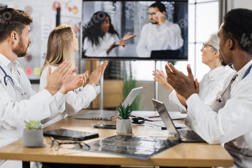 Preview: Multicultural doctors clapping during online presentation