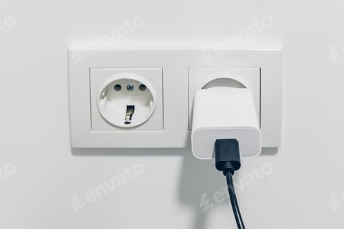 Preview: A Close View of an Electrical Wall Outlet with a Charger Plugged In, Illustrating Everyday Use