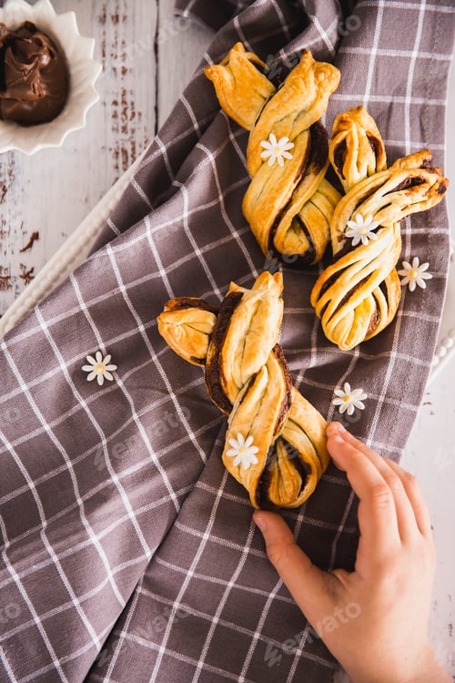 Preview: Kids hand taking delicious Palmiers with chocolate on wooden background