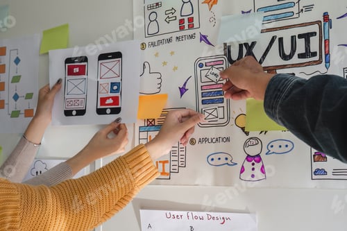 Preview: Image of a team of developers brainstorming UI and UX design ideas for a mobile app on a paper