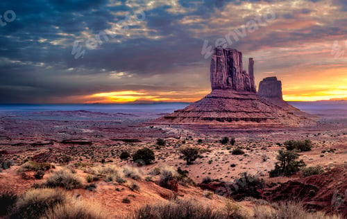 Preview: Sunset view of Monument Valley in Arizona with dramatic clouds and rock formations