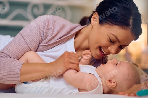 Vista previa: Joven madre feliz disfrutando del tiempo con su bebé en casa.