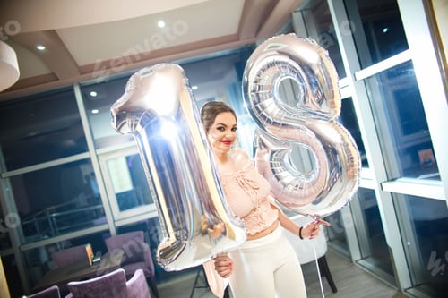 Visualização: Retrato de uma mulher morena feliz em sua festa de aniversário segurando balões nas mãos