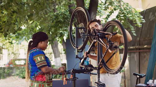 Preview: Couple working on damaged bicycle