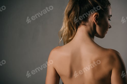 Preview: back view of woman with ponytail on grey background