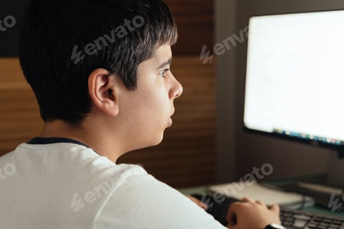 Preview: Teenager concentrated studying at home attending online classes
