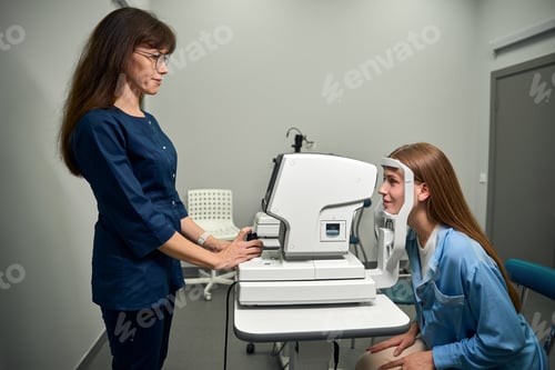 Preview: Caucasian optometrist positioning patient for eye scan procedure
