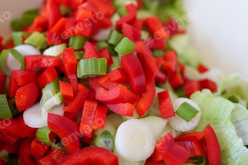 Preview: Closeup shot of a salad with sliced red peppers, onion and lettuce