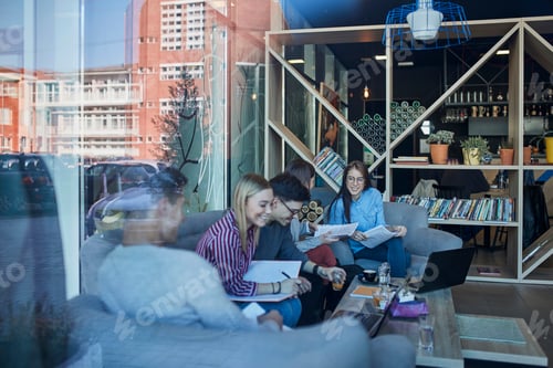 Preview: Group of friends sitting together in a cafe with reflection of glass pane