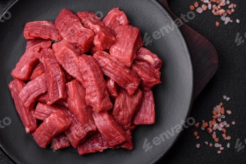 Preview: Raw organic meat beef or lamb cut into slices with salt, spices and herbs