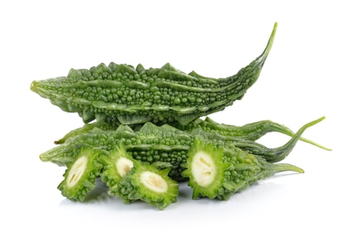 Vista previa: Rodajas de melón amargo aisladas sobre fondo blanco