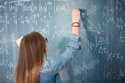 Preview: Schoolgirl With Glasses Solving Math Problem On Blackboard