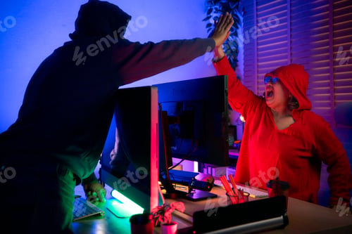 Preview: Senior couple wearing headsets and enjoying online gaming together in a neon lit room