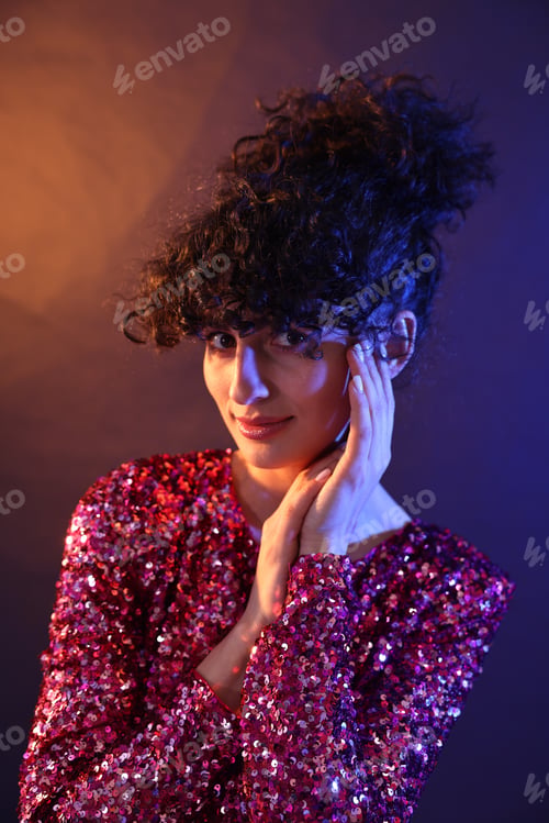 Preview: Beautiful young woman posing on color background in neon lights
