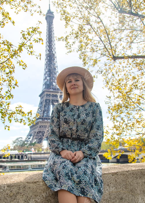 Preview: Woman in a hat near the eiffel tower. Selective focus.