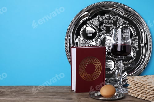 Preview: Symbolic Pesach (Passover Seder) items on wooden table against blue background, space for text