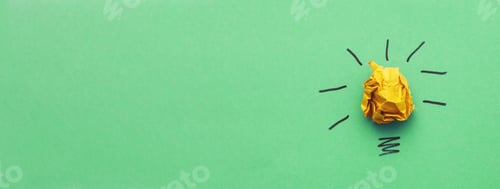Preview: crumpled yelllow paper laightbulb as a concept creative idea and innovation on a green background