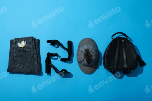 Preview: Female spring outfit with accessories on blue background, top view