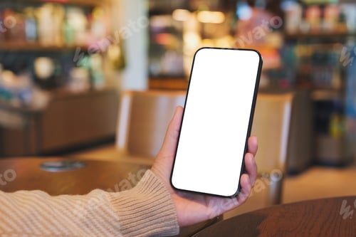 Preview: Mockup image of a woman holding and using mobile phone with blank desktop screen in cafe