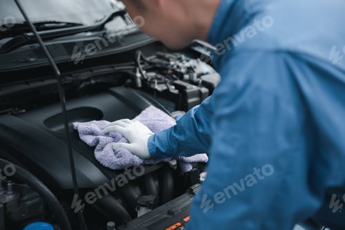 Preview: Mechanic Cleaning Engine Bay with Cloth in Garage