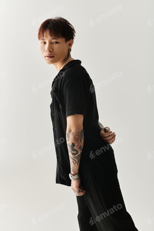 Preview: Stylish young Asian man exuding confidence with unique fashion in a minimalist setting