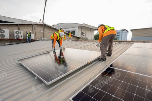 Preview: Men technicians carrying photovoltaic solar moduls on roof.