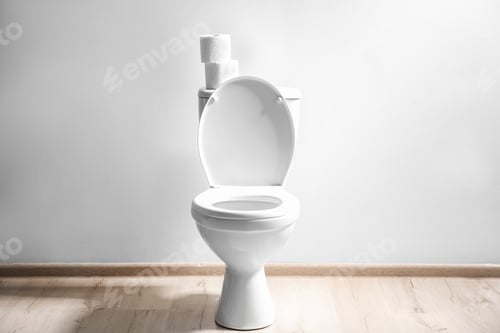 Preview: New ceramic toilet bowl near light wall