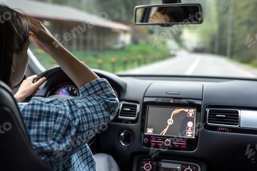 Preview: Woman driving a car, hands on the wheel close-up, view from the back to the road.