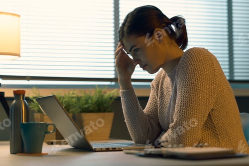 Preview: Tired woman with headache working with a laptop