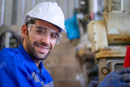 Preview: Blue collar workers at machine shop with welding robot arm.