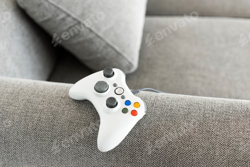 Preview: White gaming controller on a sofa
