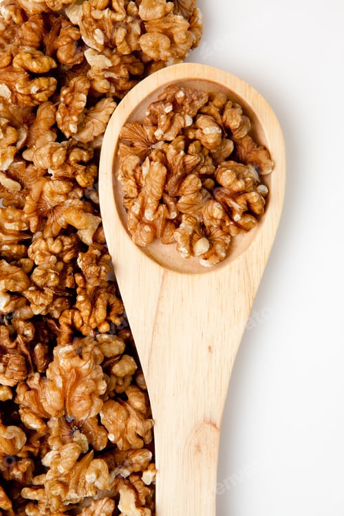 Preview: Wooden spoon with nuts against a white background