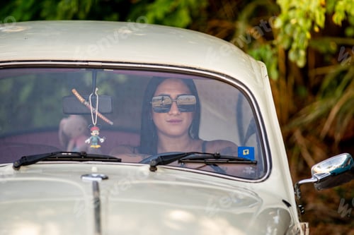 Preview: Woman driving a vintage car with sunglasses