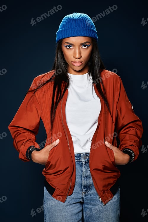 Preview: Stylish young woman in warm autumn attire poses confidently against a dark backdrop