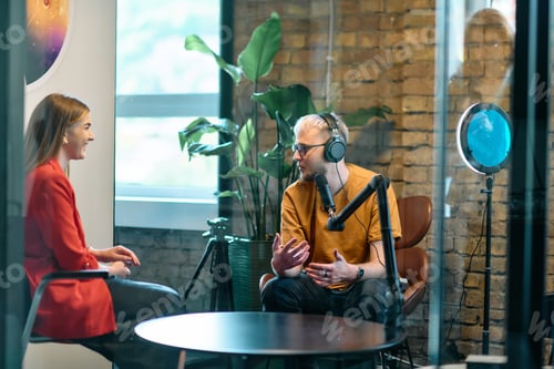 Preview: A gathering of young business professionals, some seated in a glass-walled office, engage in a