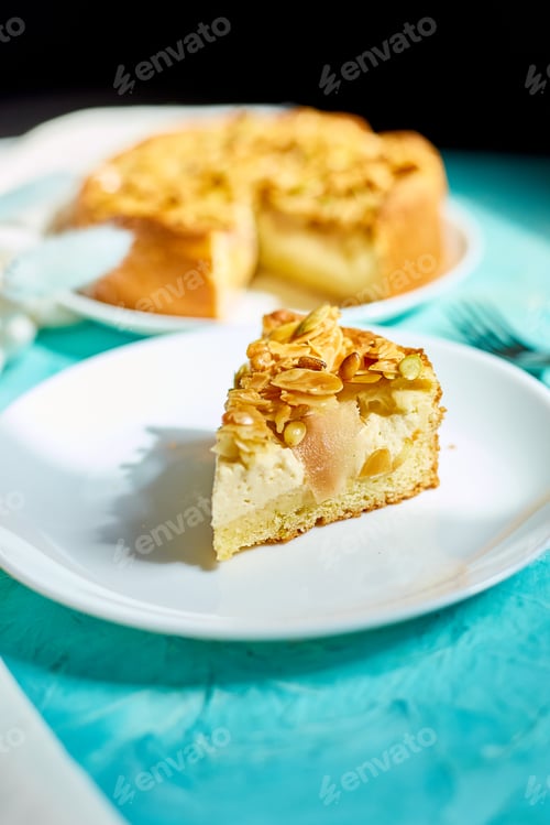 Preview: Piece of apple or pear pie, tart with caramel nuts on blue table with sunlight