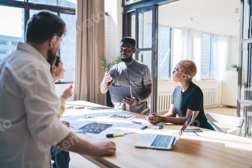 Preview: Black man speaking with colleagues during meeting