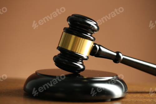 Preview: Judge's gavel and sound block on wooden table against pale brown background, closeup